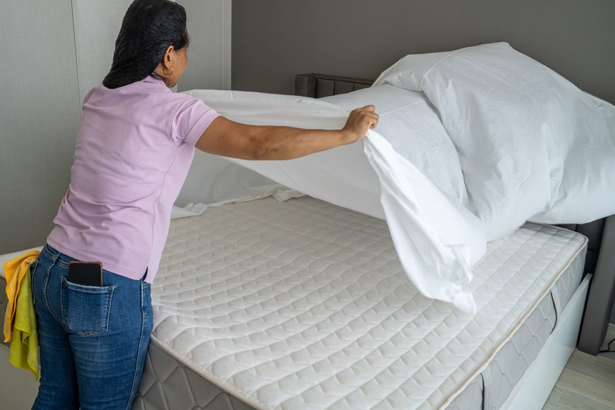 Cleaner making a bed after cleaning