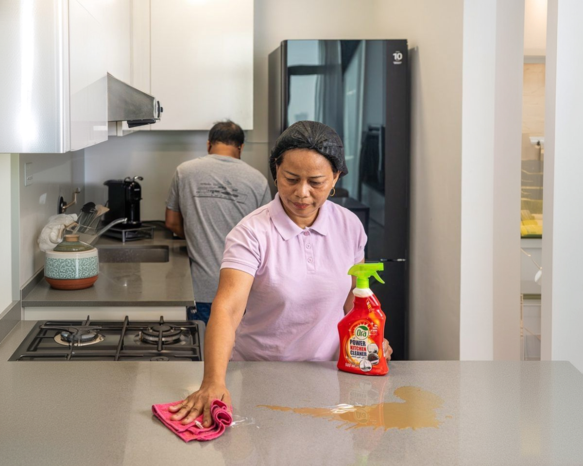 Cleaner wiping a kitchen surface